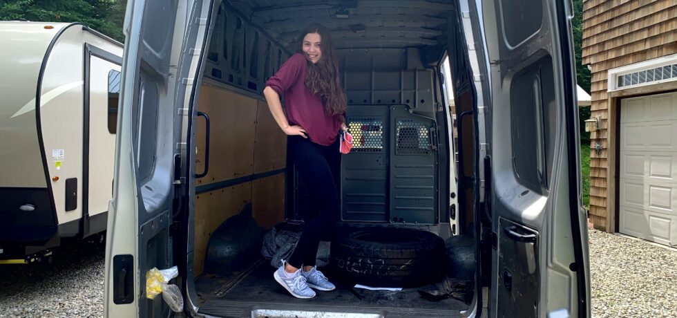 Woman standing in back of opened Camper Van