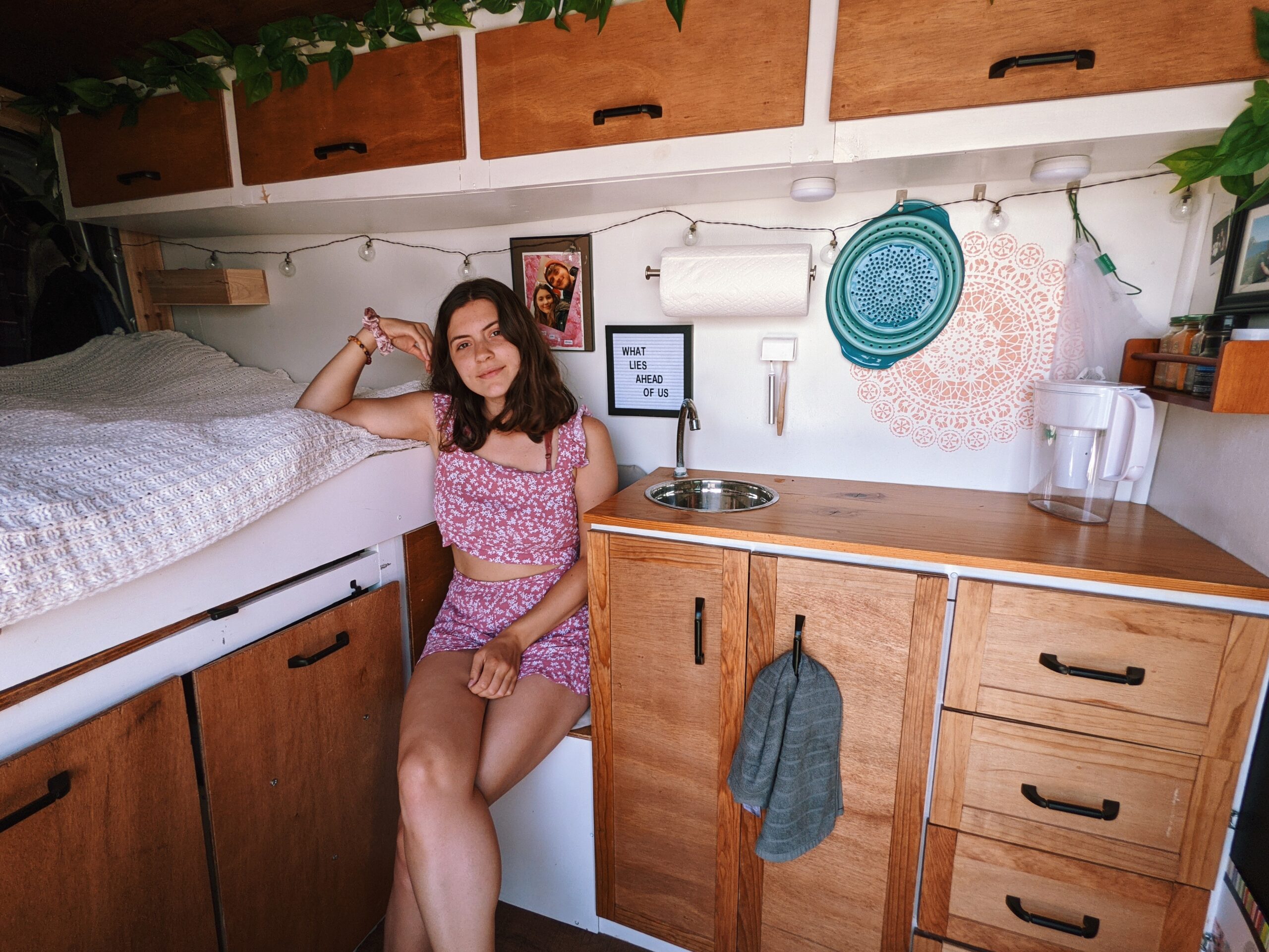 Interior view of a young woman sitting in a DIY van build