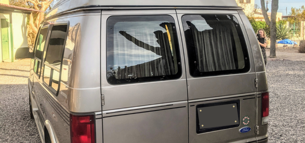 Grey Ford Econoline with stationary windows
