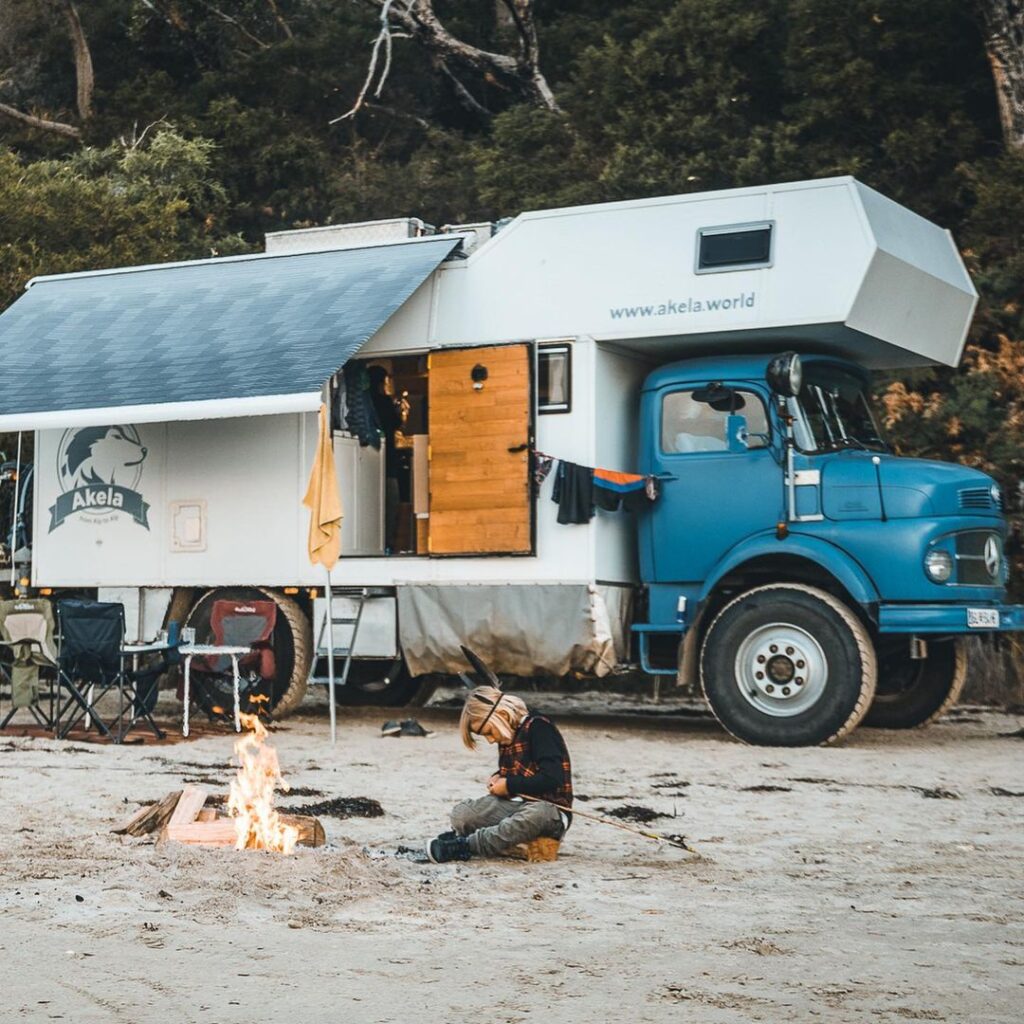 Young boy working on a fire outside of renovated truck in Tasmania