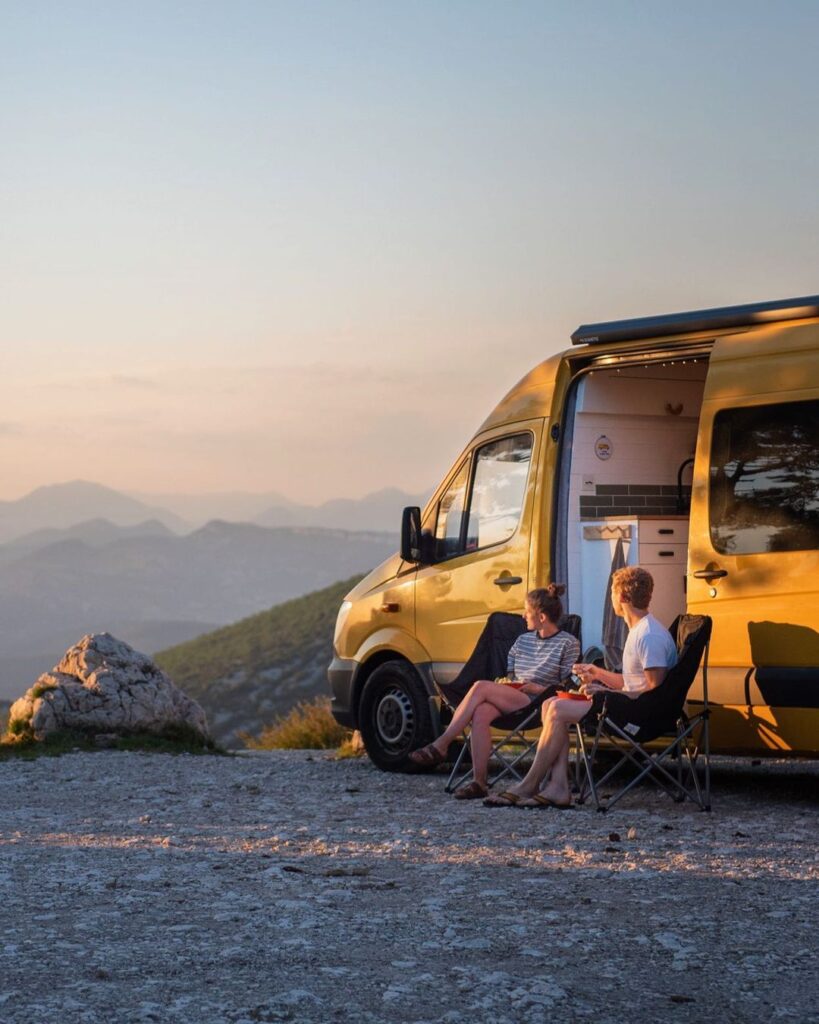 Charlie and Dale enjoy a sunset and dinner while sitting outside of their van