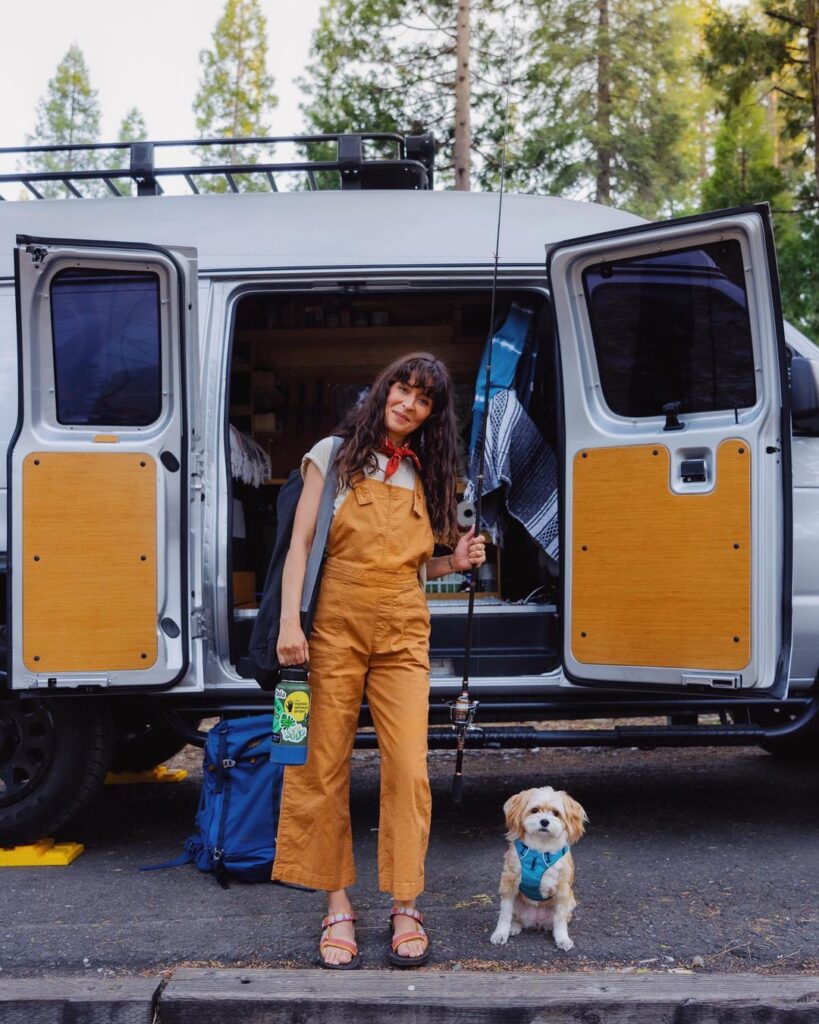 Woman and her dog outside of her van about to go fishing