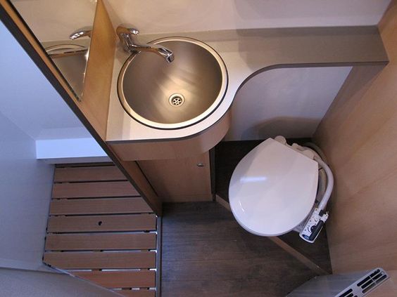 A flush toilet located in the bathroom area of a large camper van.