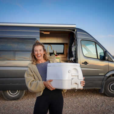 Woman holding a toilet outside of a camper van