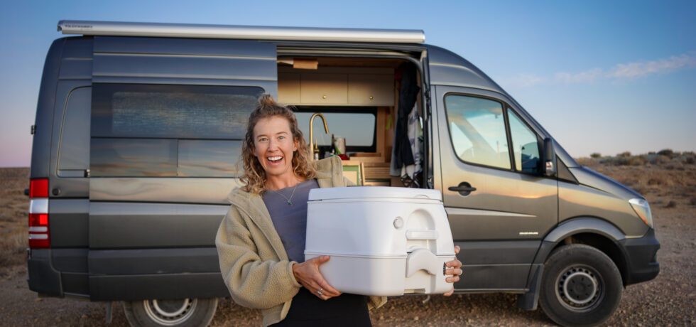 Woman holding a toilet outside of a camper van
