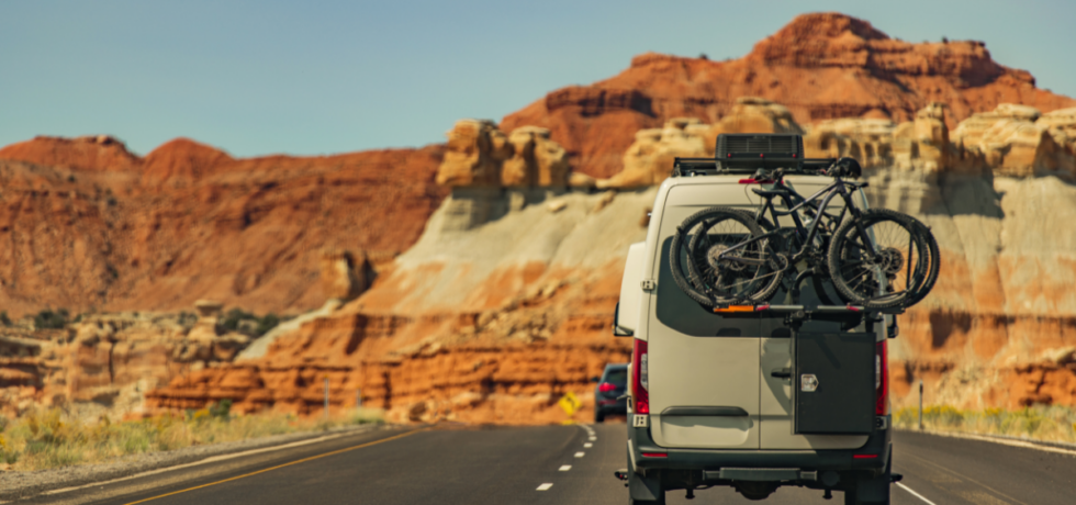 A camper van driving down a desert highway