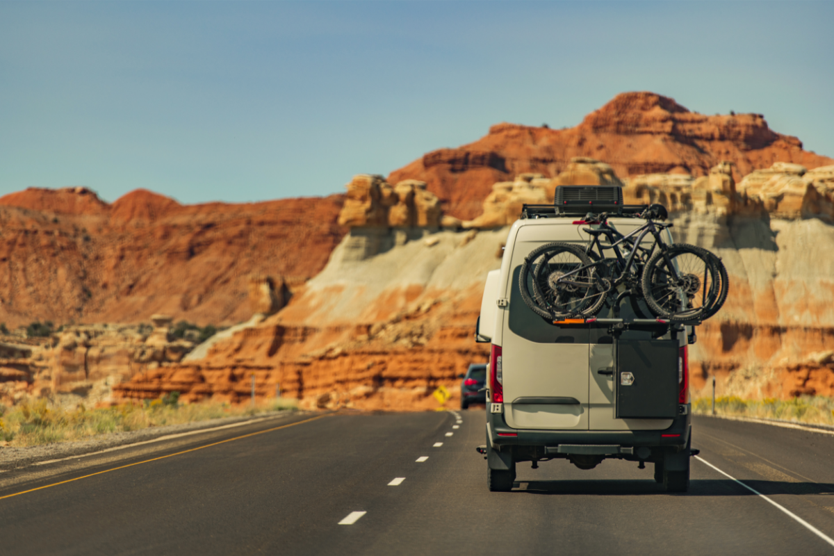 A camper van driving down a desert highway