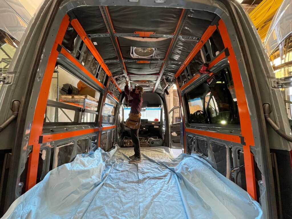Man installing an Adventure Wagon conversion kit in the inside of a van