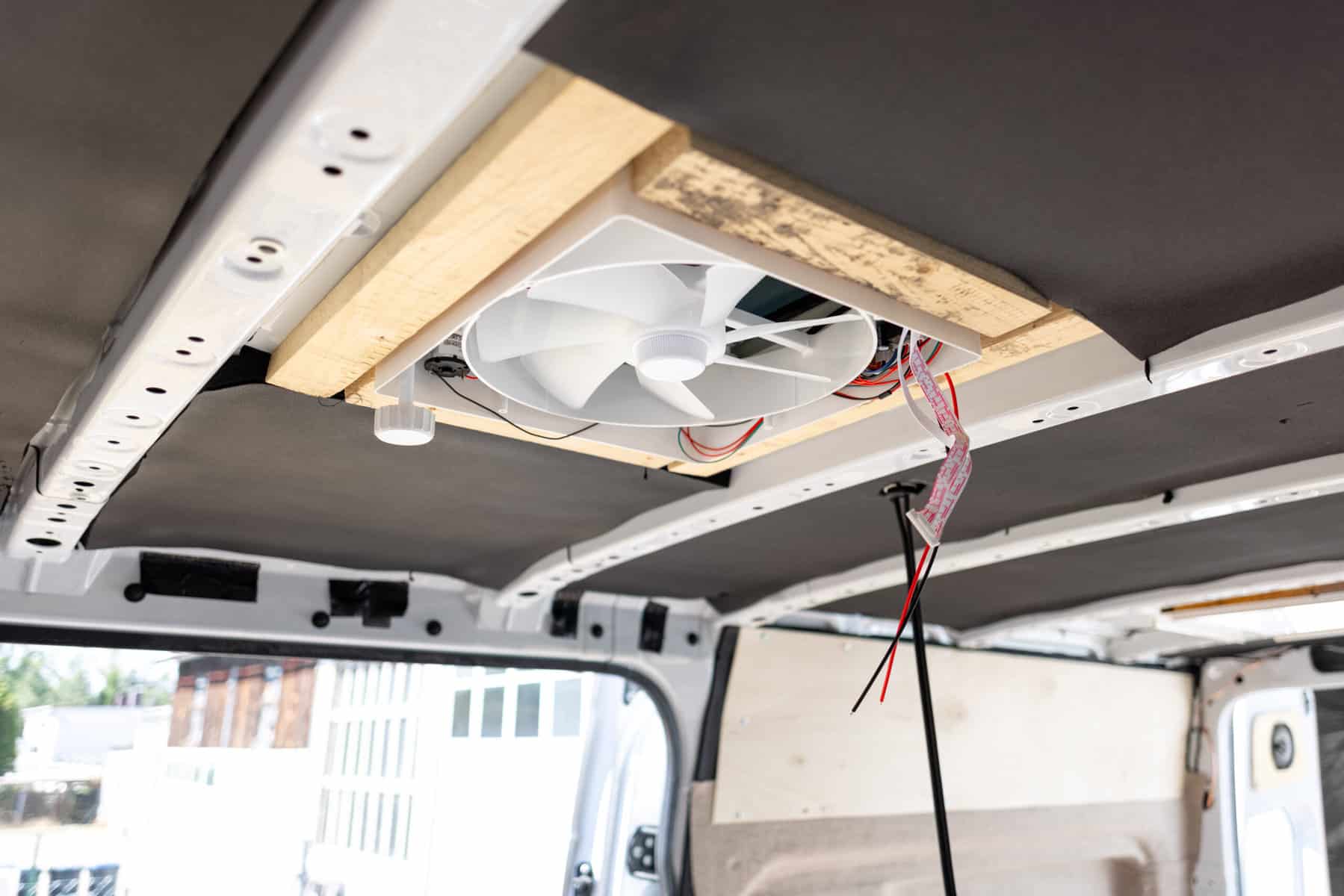 Roof fan with unattached wires installed in unfinished camper van