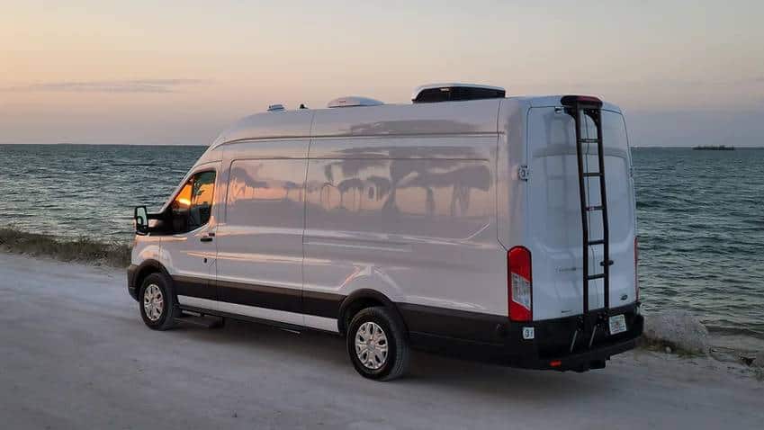 Stealth Camper Van parked on road in font of ocean scene