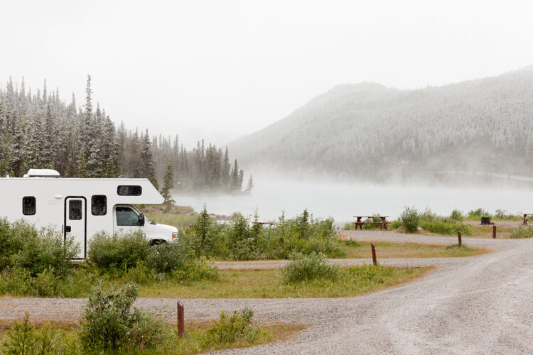 RV in a campground by a lake with mist over the water.