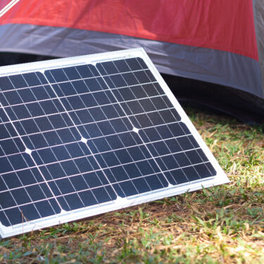 A portable solar panel charges in the sun.