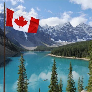 A Canadian flag flying in front of a lake