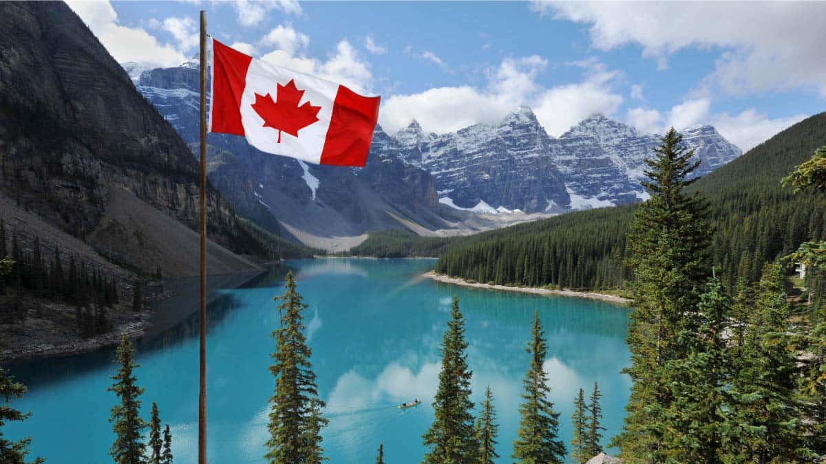 A Canadian flag flying in front of a lake