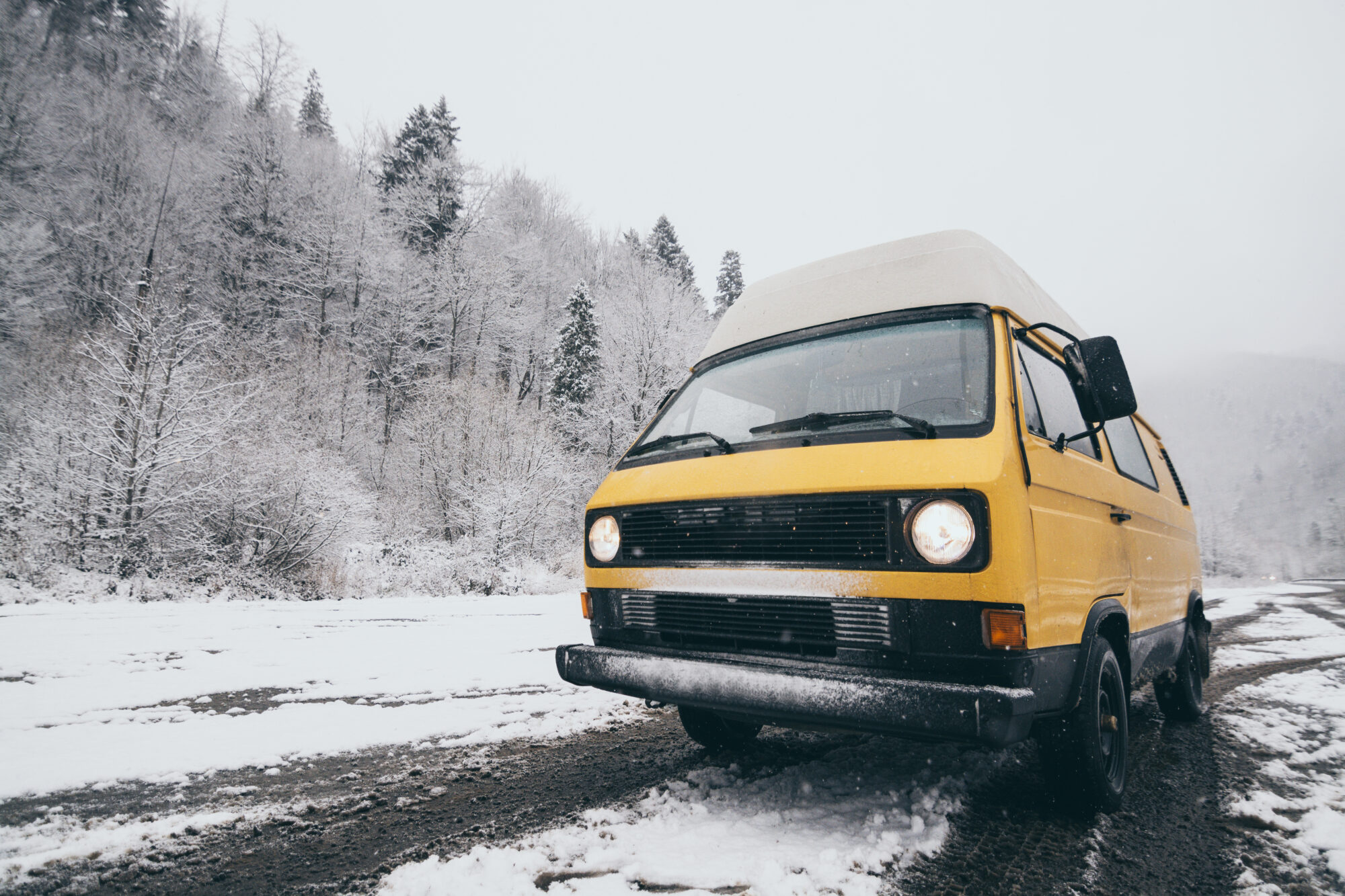 Yellow Volkswagen van on a snowy road - best insulation for a camper van