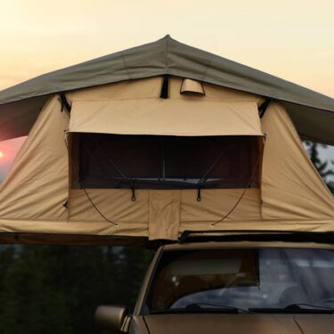 yellow popup tent on the rooftop of an SUV in mountains