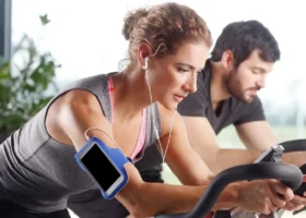 Man and woman at the gym on exercise bikes.