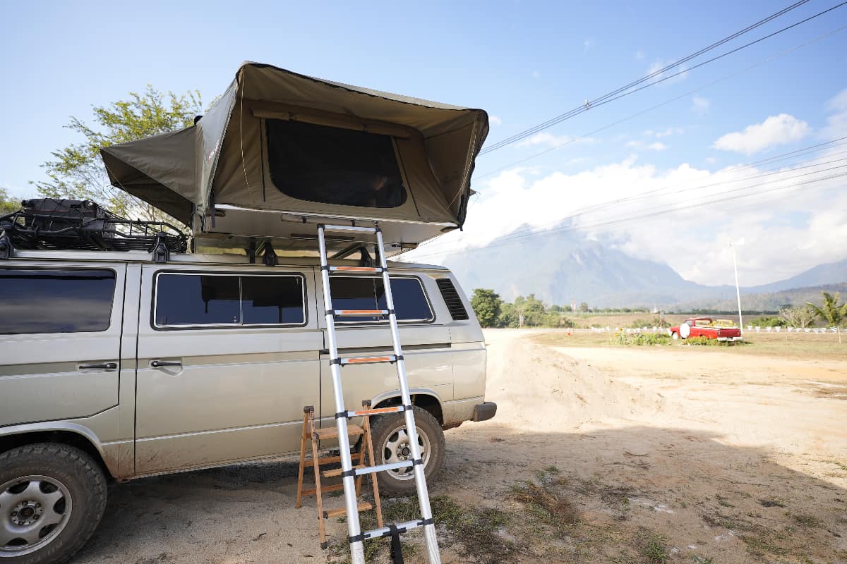 Camper van parked in natural outdoor with rooftop tent. 