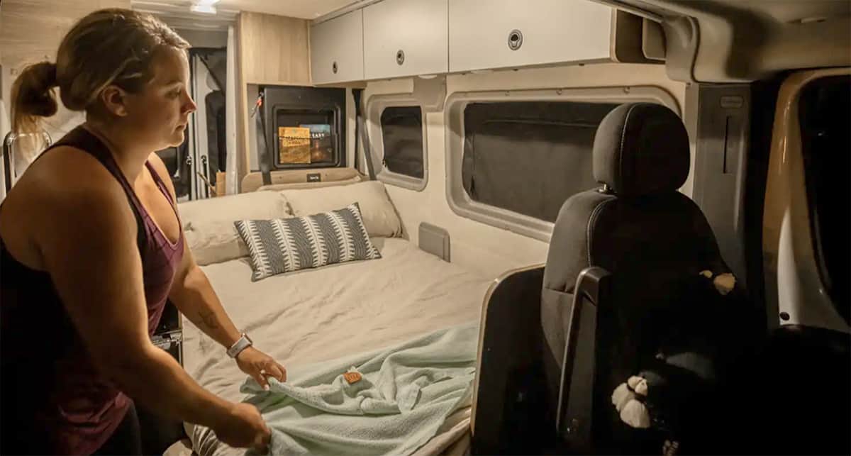 Woman making the bed in the Solis Pocket van