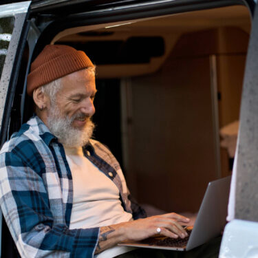 A man using the internet in his van.