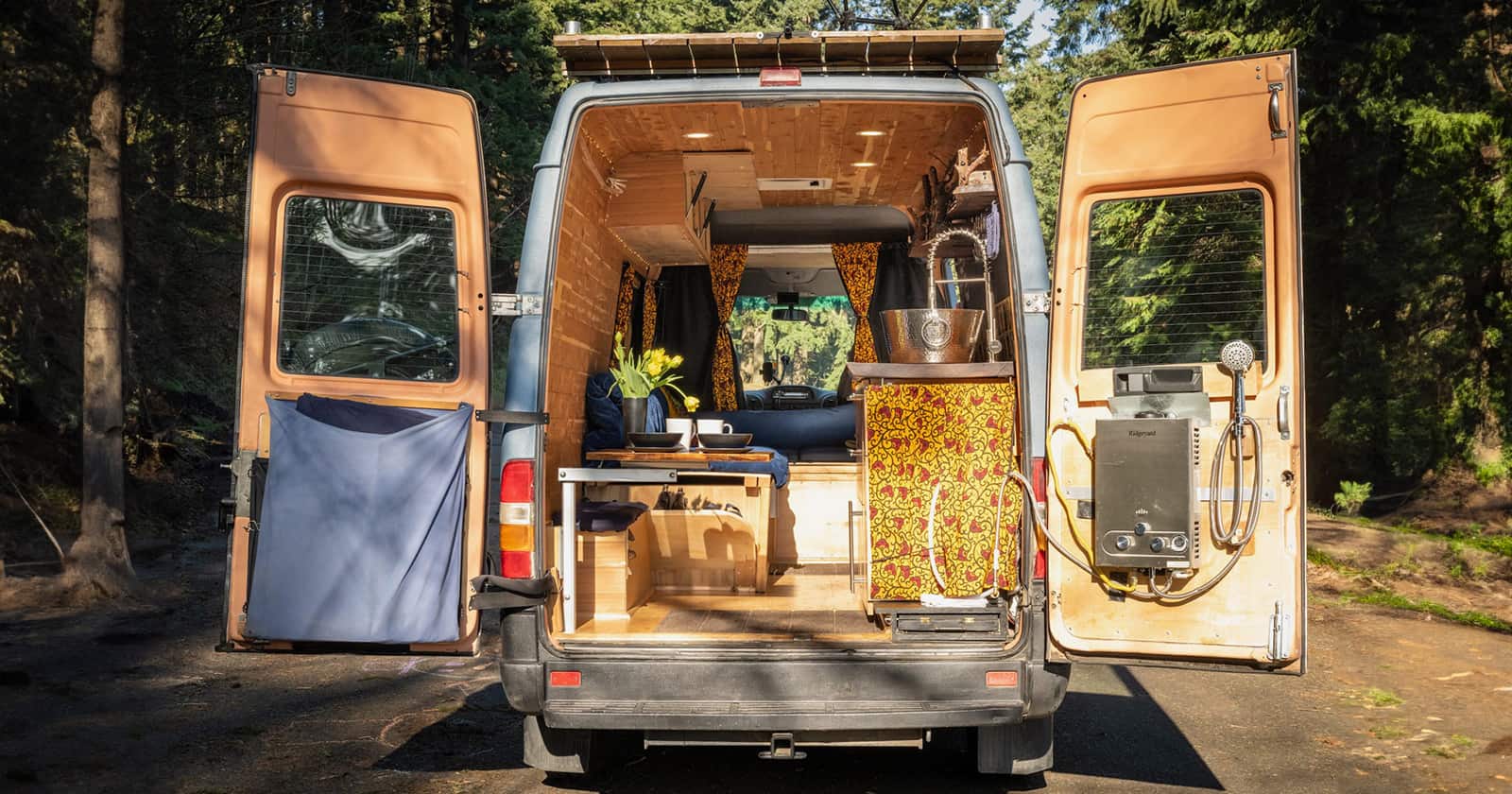 A van conversion with the back doors open showing the living area.